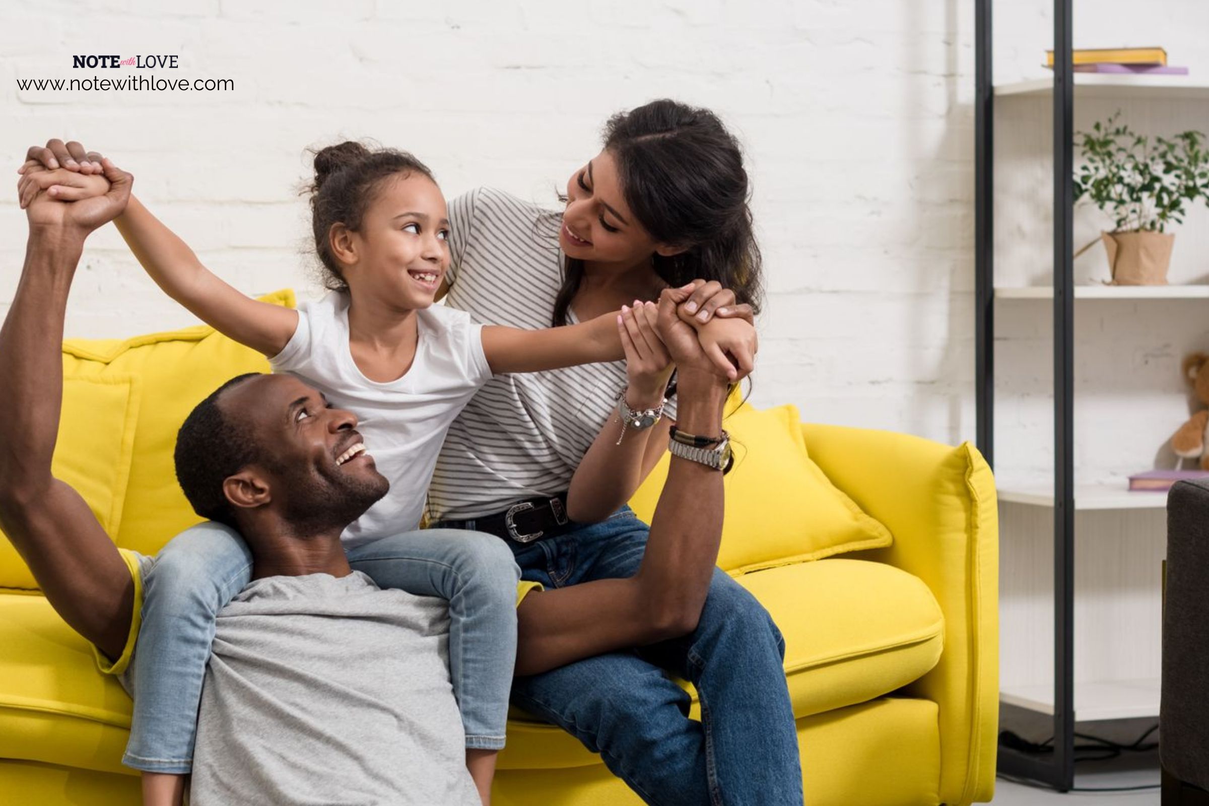 Family of three enjoying time together on a couch in their living area.