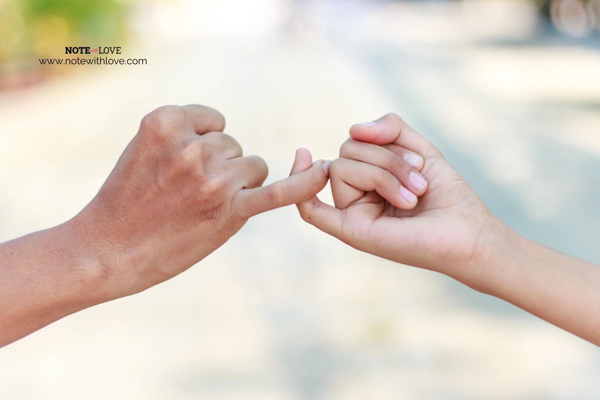 Two people making a pact by shaking their pinkies